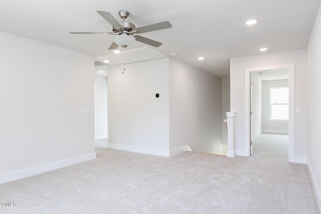 spare room with attic access, a ceiling fan, recessed lighting, light colored carpet, and baseboards