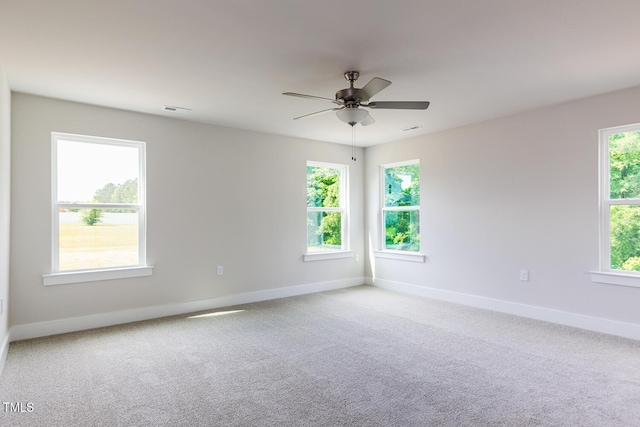 carpeted spare room with baseboards and a ceiling fan