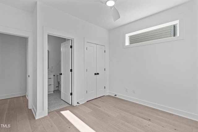 unfurnished bedroom with light wood-type flooring, a ceiling fan, baseboards, and connected bathroom