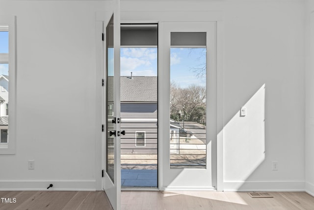 entryway with visible vents, baseboards, and wood finished floors