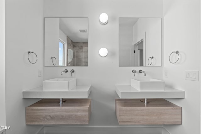 bathroom featuring visible vents, a sink, and double vanity