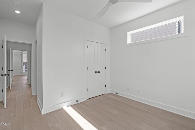 unfurnished bedroom with recessed lighting, a closet, light wood-style flooring, and baseboards