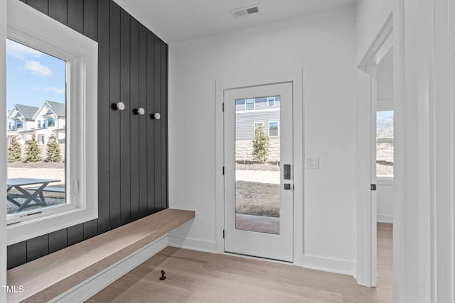 interior space featuring light wood-type flooring, baseboards, visible vents, and a wealth of natural light