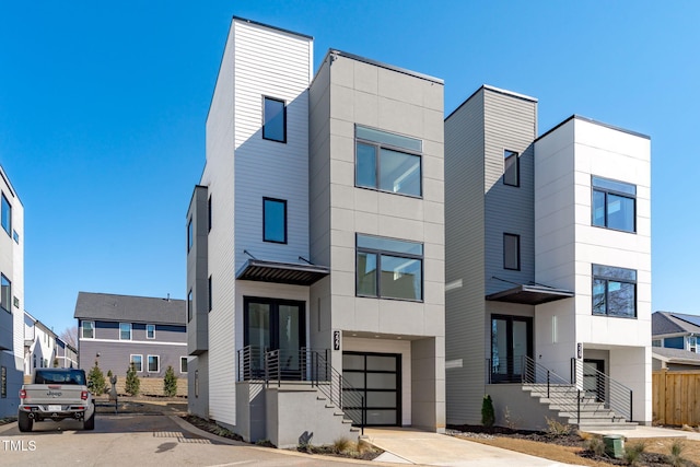contemporary home featuring concrete driveway, a garage, and french doors