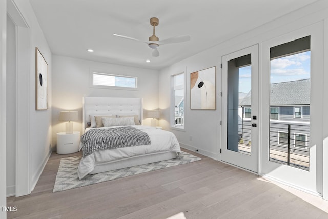 bedroom featuring access to exterior, baseboards, and wood finished floors