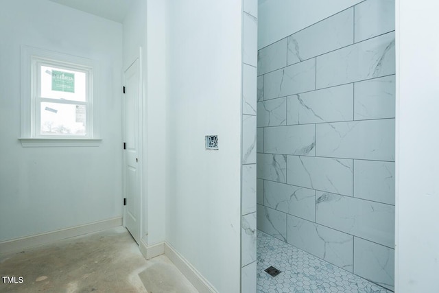 bathroom featuring concrete floors and a tile shower