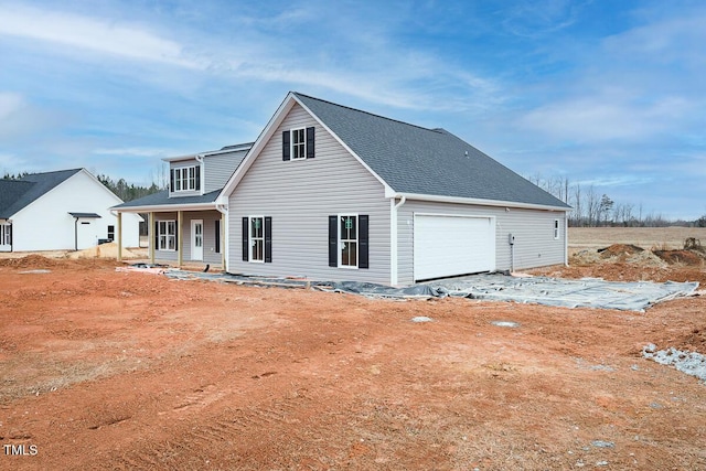 rear view of property featuring a porch and a garage