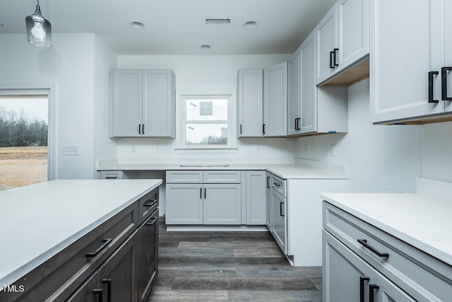 kitchen featuring hanging light fixtures, dark wood-style floors, light stone counters, and recessed lighting