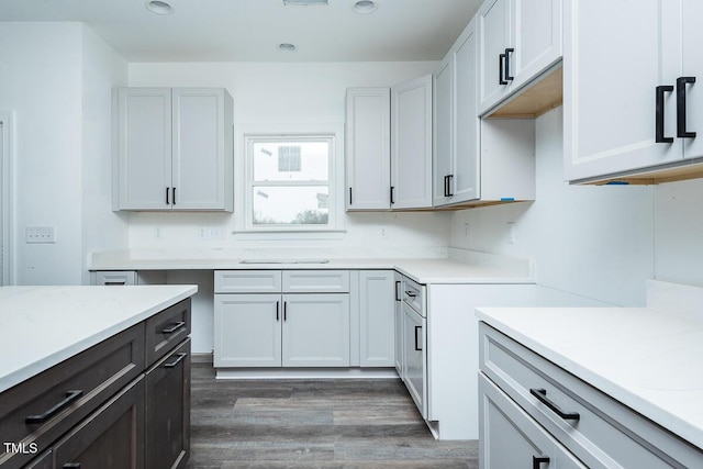 kitchen featuring dark wood-style floors, light countertops, dark brown cabinets, and white cabinetry