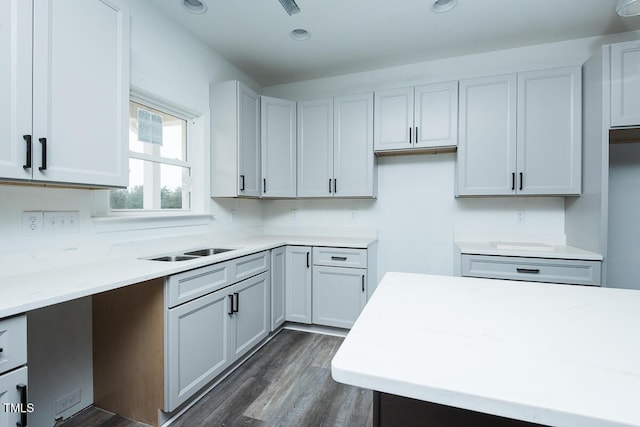 kitchen with dark wood-type flooring, light stone counters, and recessed lighting