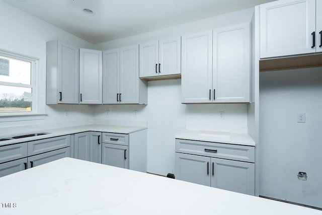 kitchen featuring gray cabinets and light stone countertops