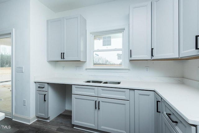 kitchen with light countertops, a sink, and gray cabinetry