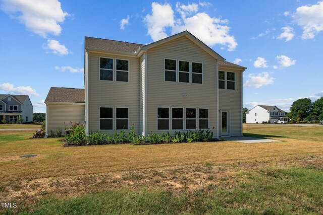 rear view of property featuring a yard and a patio area