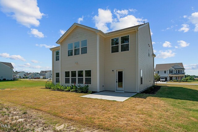 back of house with a patio area and a yard