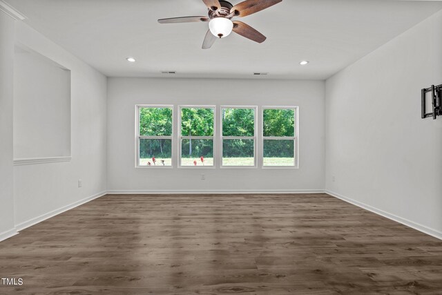 unfurnished room with a healthy amount of sunlight, ceiling fan, and hardwood / wood-style floors