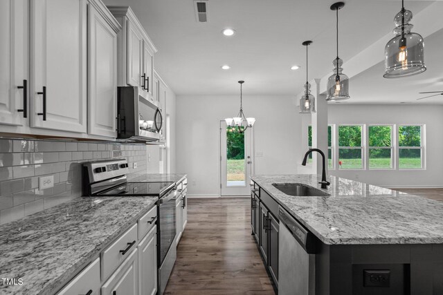 kitchen with white cabinetry, wood-type flooring, decorative backsplash, sink, and appliances with stainless steel finishes