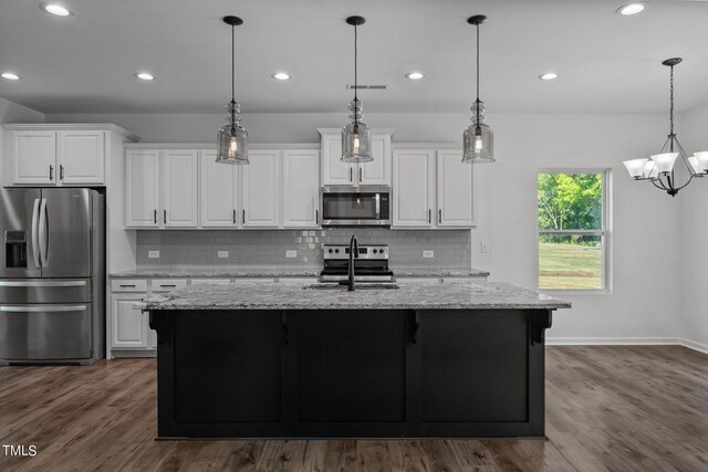 kitchen featuring hardwood / wood-style floors, white cabinetry, stainless steel appliances, and backsplash