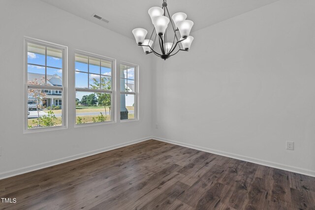 unfurnished room with a notable chandelier, hardwood / wood-style floors, and plenty of natural light