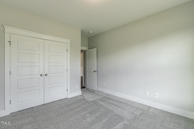 unfurnished bedroom featuring light colored carpet and a closet