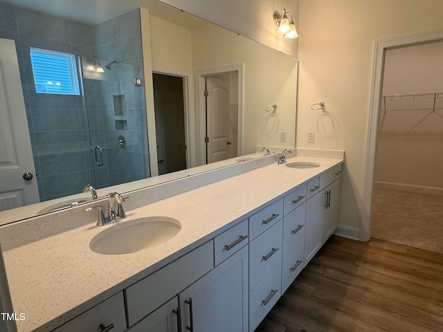 bathroom featuring hardwood / wood-style flooring, vanity, and walk in shower