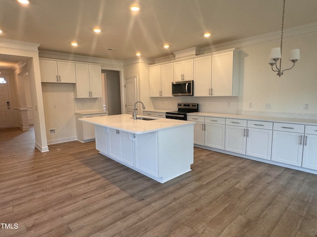 kitchen featuring hanging light fixtures, white cabinetry, appliances with stainless steel finishes, and sink