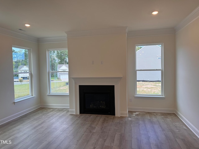 unfurnished living room with hardwood / wood-style flooring and ornamental molding