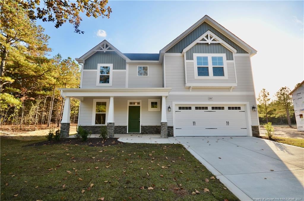 craftsman house with a garage, a front lawn, and a porch