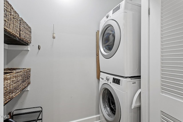 clothes washing area featuring stacked washer / drying machine