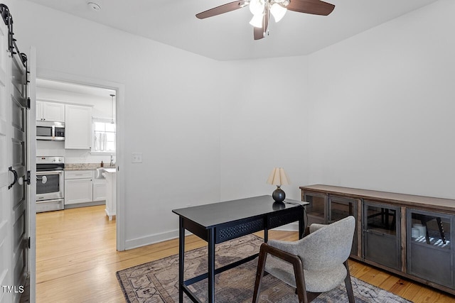 office area with ceiling fan and light hardwood / wood-style floors