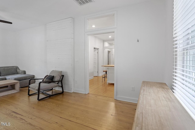 living area featuring light wood-type flooring and ceiling fan