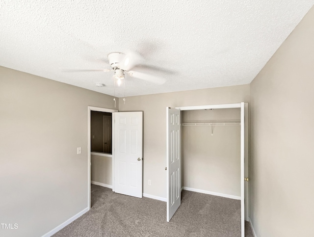 unfurnished bedroom featuring dark colored carpet, a textured ceiling, a closet, and ceiling fan