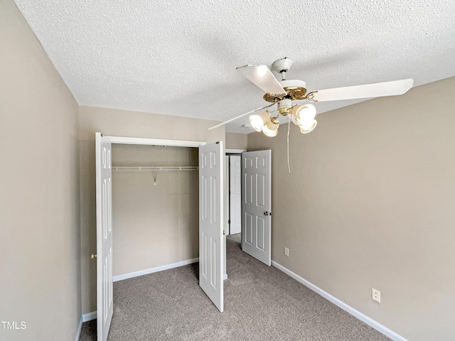 unfurnished bedroom featuring ceiling fan, a closet, carpet, and a textured ceiling