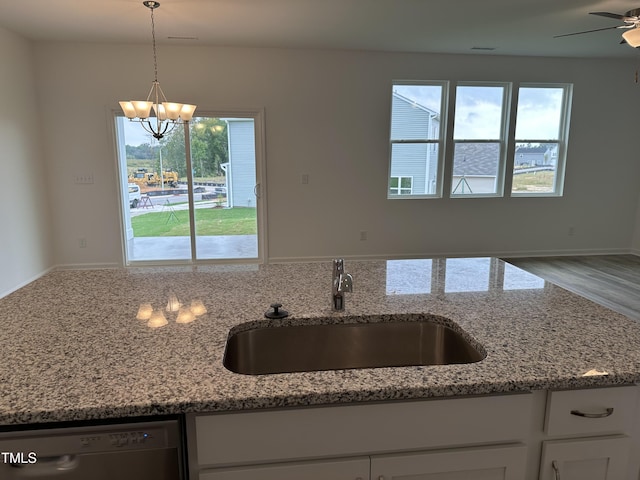 kitchen with dishwasher, light stone countertops, white cabinetry, and a sink