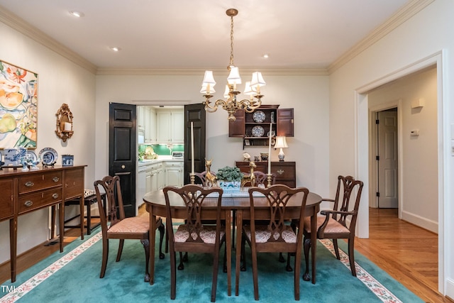 dining room featuring hardwood / wood-style floors, crown molding, and a notable chandelier