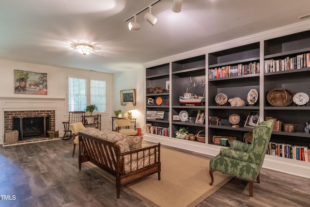 living area with a fireplace, wood-type flooring, and track lighting