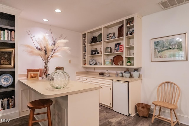 bar with dishwasher, sink, dark hardwood / wood-style flooring, fridge, and white cabinets