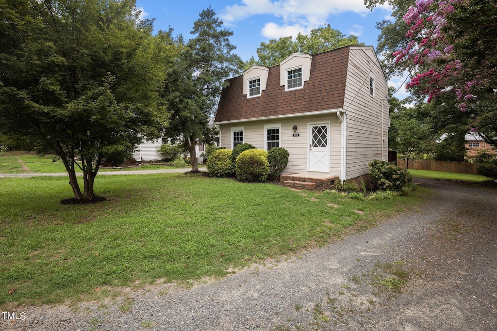 cape cod house featuring a front yard