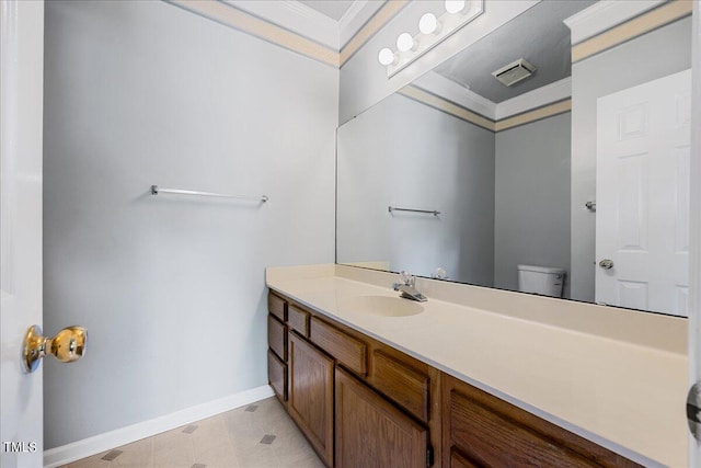 half bathroom with toilet, ornamental molding, vanity, and baseboards