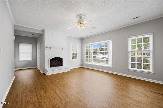 unfurnished living room featuring a fireplace, visible vents, ceiling fan, wood finished floors, and baseboards