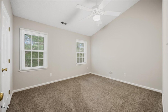 empty room featuring carpet floors, visible vents, a ceiling fan, vaulted ceiling, and baseboards