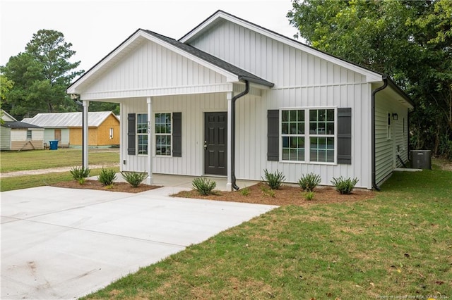 modern farmhouse style home featuring a porch, board and batten siding, and a front yard