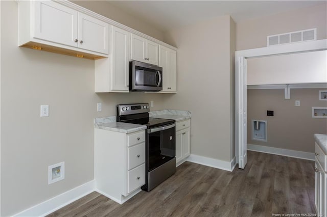 kitchen featuring baseboards, stainless steel appliances, visible vents, and white cabinetry