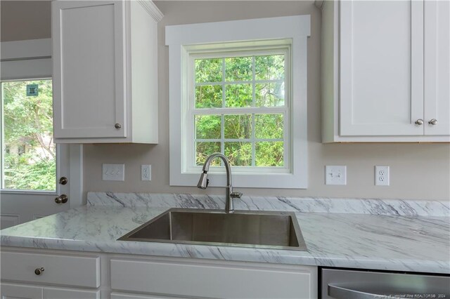 kitchen featuring a wealth of natural light, white cabinetry, and sink