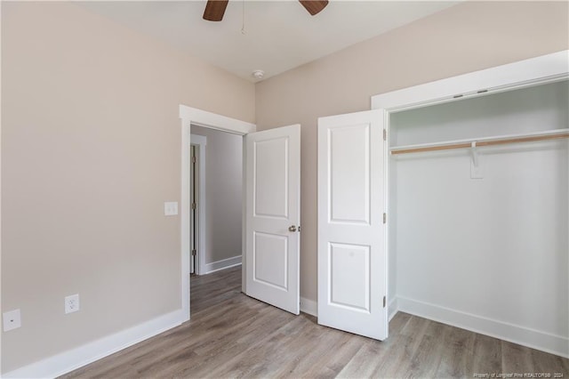 unfurnished bedroom featuring ceiling fan, a closet, wood finished floors, and baseboards