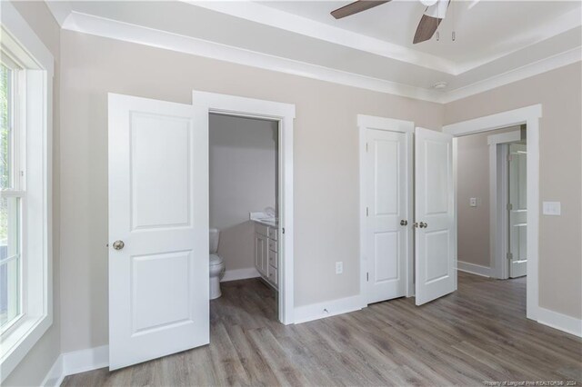 unfurnished bedroom featuring ceiling fan, connected bathroom, and light hardwood / wood-style flooring