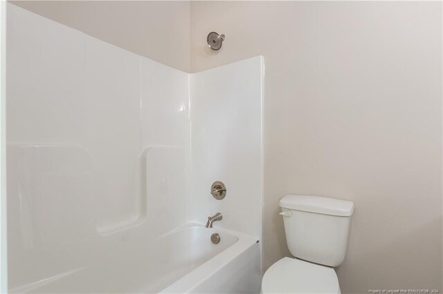 bathroom with bathing tub / shower combination and toilet