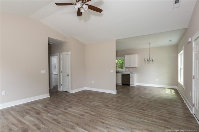 unfurnished living room featuring lofted ceiling, ceiling fan with notable chandelier, dark wood-style flooring, visible vents, and baseboards