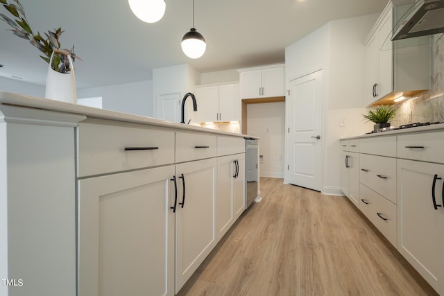 154 Swain St, Clayton, NC 27527 - kitchen featuring pendant lighting, dishwasher, wall chimney exhaust hood, light hardwood / wood-style floors, and white cabinetry