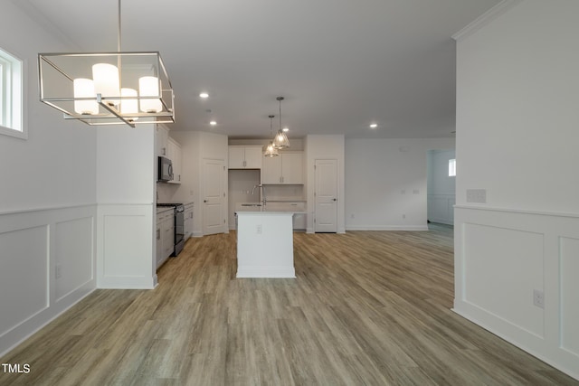 154 Swain St, Clayton, NC 27527 - kitchen featuring stove, an inviting chandelier, white cabinets, a center island, and light hardwood / wood-style floors