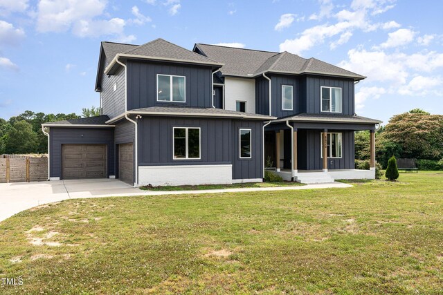 view of front of home with a front yard, a porch, and a garage